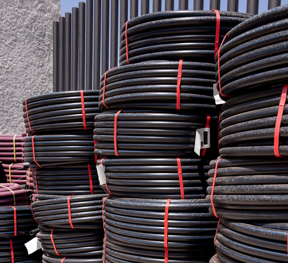 Coiled black polyethylene pipes made from Iran HDPE, highlighting durability and high performance for industrial and agricultural applications.